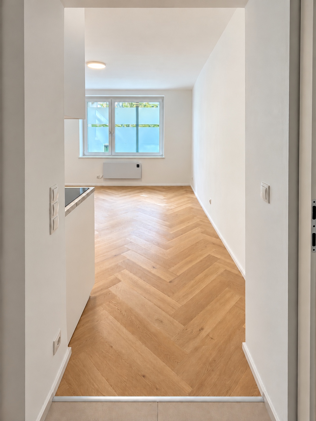 Blick vom Eingang in den sanierten Wohnraum mit Fischgrätboden in 1130 Wien, KI-bearbeitetes Projektfoto